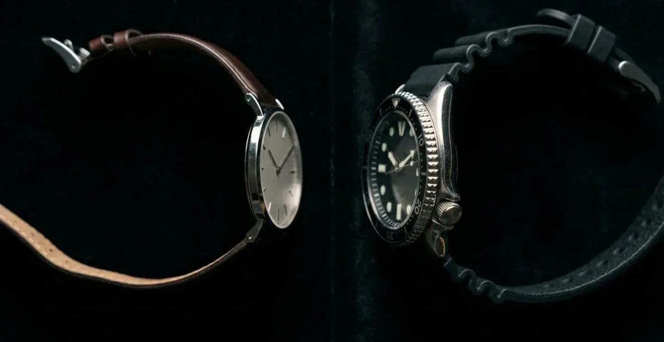 Side-by-side comparison of a slim dress watch with leather strap next to a bulky diver's watch on black velvet
