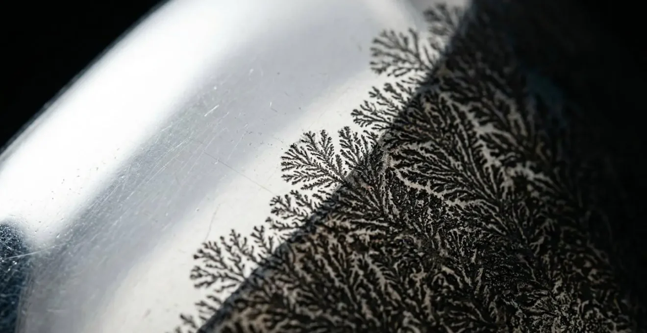 Extreme close-up showing silver surface tarnishing from adhesive off-gassing